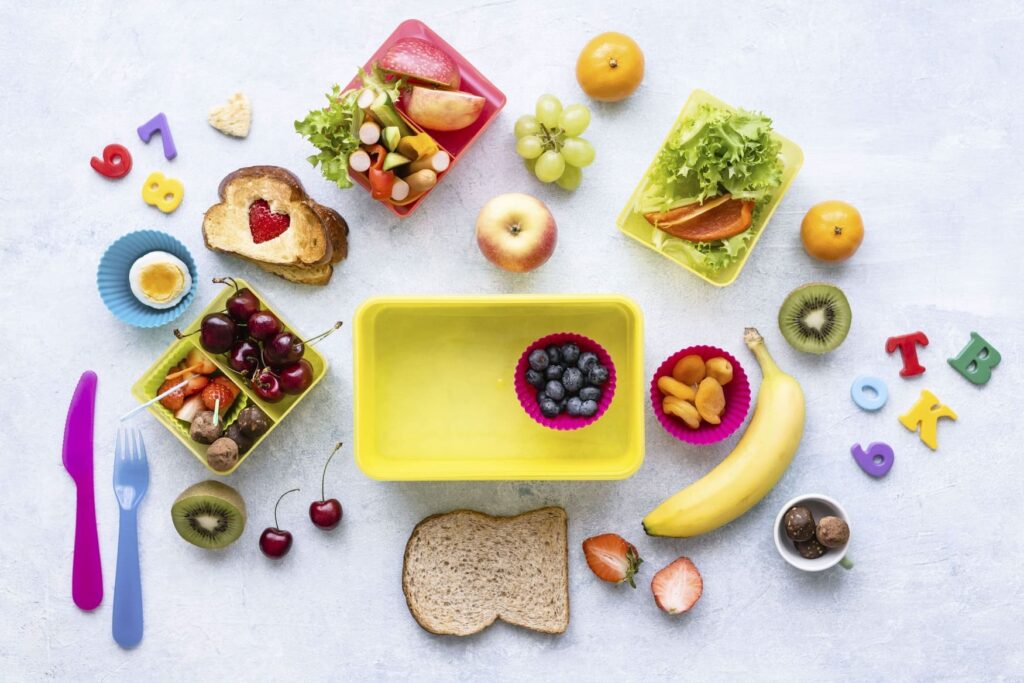 Nourriture pour le goûter des enfants avec des fruits, légumes, du sucré et du salé.